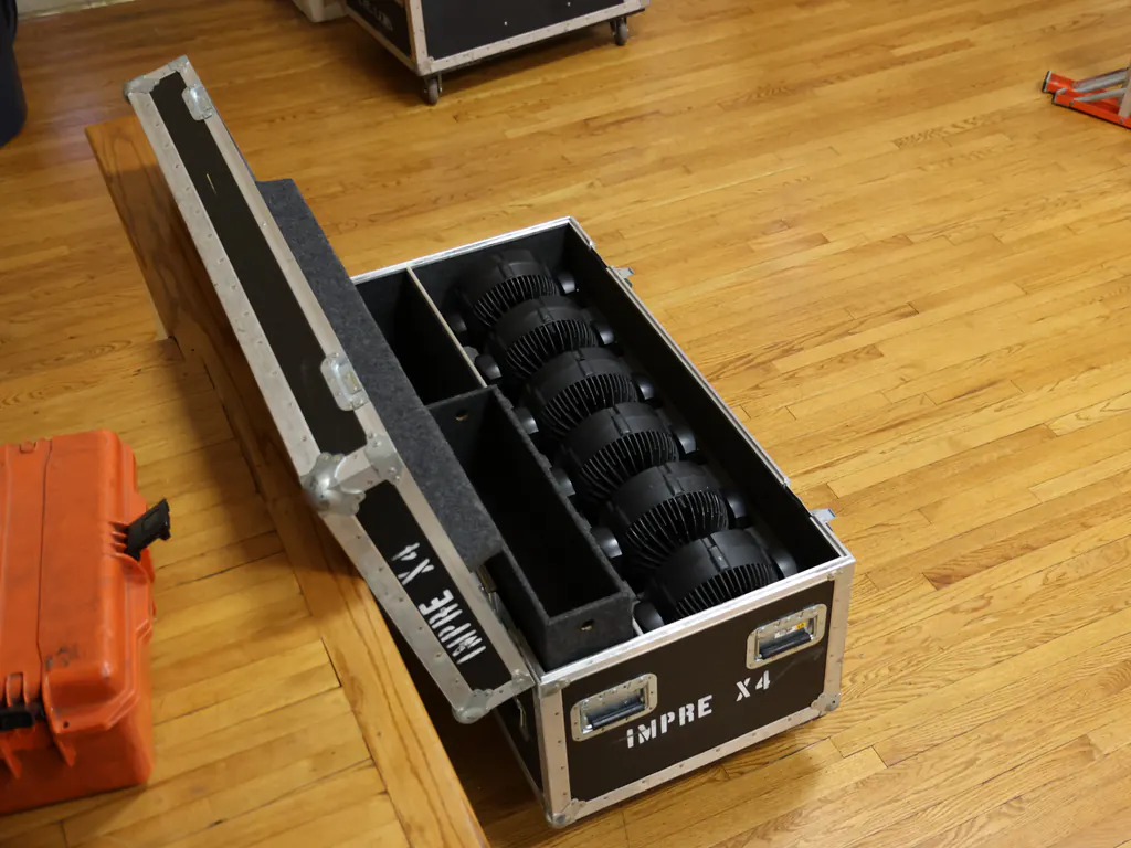 Six LED wash fixtures nested in the fitted road case they ship in, lid open.